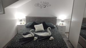 two swans are sitting on a bed in a bedroom at Apartment Mali Raj -Stunning Gacka River View-Peaceful Nature Escape in Otočac
