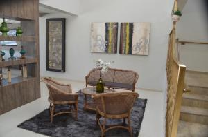 a dining room with a table and wicker chairs at Hotel Queijo & Cia in Capão Alto