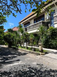 a house with palm trees in front of a street at Largest Villa in Kuta Royal C1 - Turquoise Villa in Kuta