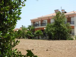 スカラ・エレソスにあるSkala Eresos Paradise Studiosの目の前に木々が生い茂る建物