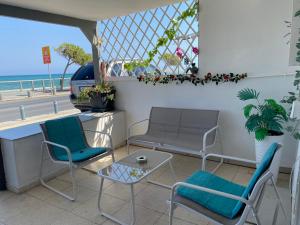 d'une terrasse avec des chaises et une table et une vue sur la plage. dans l'établissement Mackenzie By the sea one bed Ground floor home, à Larnaka