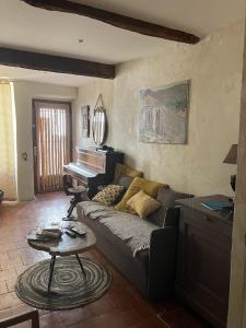 a living room with a couch and a piano at 17th CENTURY HOUSE with terrace, near to Castle in Capendu