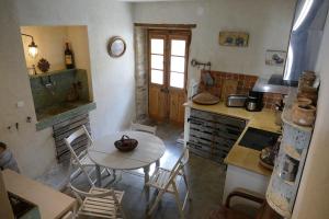 a kitchen with a table and a table and chairs at 17th CENTURY HOUSE with terrace, near to Castle in Capendu