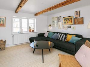 a living room with a green couch and a table at 5 person holiday home in Løkken in Løkken