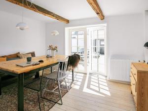 a kitchen and dining room with a table and chairs at 5 person holiday home in Løkken in Løkken +18 photos