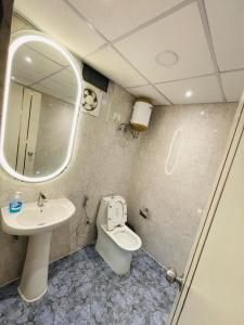 a bathroom with a sink and a toilet and a mirror at Cozy Noida studio,Super comfy! in Noida