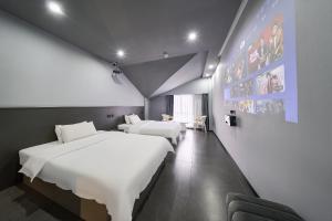 a hotel room with two beds and a chair at ZhangJiaJieWuLingYuan栖见云舍Hotel in Hanqiyu
