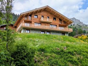 een huis bovenop een grasheuvel bij Chalet La Tanière avec Sauna in Le Grand-Bornand