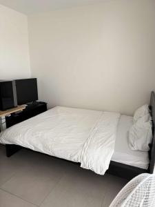 una camera da letto con letto con lenzuola bianche e scrivania di Cloche d'or studio sleeps 2 a Lussemburgo