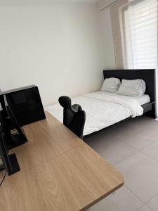 una camera da letto con un letto e una scrivania con una televisione di Cloche d'or studio sleeps 2 a Lussemburgo