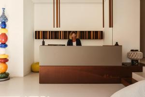 a woman standing behind a counter in a room at Hotel Tannure in San Vito lo Capo