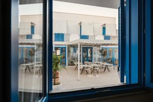 a window view of a patio with tables and chairs at Hotel Tannure in San Vito lo Capo +57 photos