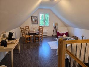 un soggiorno con tavolo, sedie e scala di Logement sur la Loire à vélo a Montlouis-sur-Loire