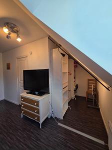 una stanza con una tv e una scrivania con una cassettiera di Logement sur la Loire à vélo a Montlouis-sur-Loire