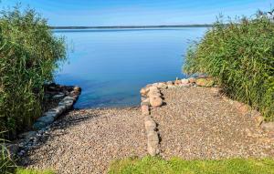 a rock path leading into the water with a rock wall at Nice Apartment In Nowe Warpno With Wifi in Nowe Warpno +6 photos
