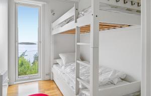 Letto a castello bianco in una camera bianca con finestra di 4 Bedroom Nice Home In Jørpeland a Jørpeland Altre 12 foto