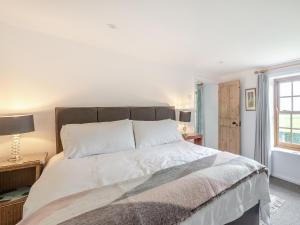 a bedroom with a large bed and a window at Peaceful Farmhouse - Uk44787 in Grainthorpe