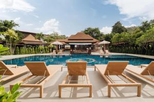 a swimming pool with chairs and a resort at Ibiza House Phi Phi in Phi Phi Islands