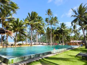 a pool with palm trees and people in the water at Blue Haven Bay Villas and Resort Apartments in Ko Chang