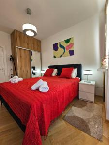 Un dormitorio con una cama roja con dos toallas encima. en Apartmani Giga, en Vrnjci