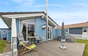 a deck with chairs and a table on a house at Friedrichskoog-Deichblick 4 in Friedrichskoog