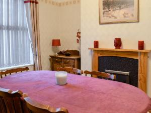 a purple table with chairs and a candle on it at Middleton House in Filey