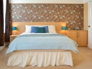 a bedroom with a large bed with blue pillows at Middleton House in Filey +10 photos