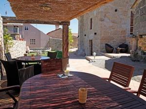 a patio with a wooden table and chairs and a table and chairs at Casa Noelmar in Combarro