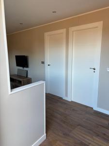 Habitación con puerta blanca y TV en Casa Cortina, en Ujo 3 fotos más