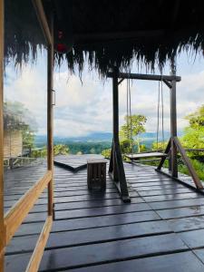 a wooden deck with swings and a hammock on it at Meghrani Eco Cottage in Māhmuam
