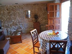 a living room with a table and a stone wall at Casa Noelmar in Combarro