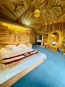 a bedroom with a large bed in a wooden room at Meghrani Eco Cottage in Māhmuam +14 photos