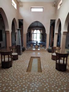 a large room with a lobby with chairs and a rug at Riad safari camp in Merzouga