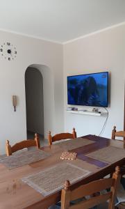 a room with a table and a tv on a wall at La Casa del Mugnaio in Rotonda