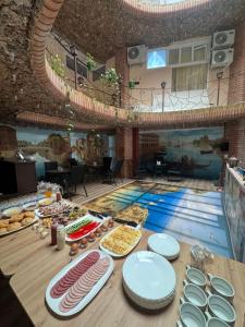a swimming pool with food on a table in front of it at Equator Hostel in Chişinău