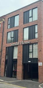 Un gran edificio de ladrillo con un cartel que dice "casa sándwich" en New 1 Bedroom Apartment Near Sheffield United Football Club, WiFi, Parking & Much More, en Sheffield