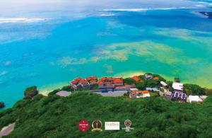 a group of houses on a hill next to the ocean at Hyakunagaran in Nanjo