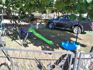 einen Spielplatz mit einem Auto und einer grünen Rutsche und einem Fahrrad in der Unterkunft Apartment Vlado in Sukošan