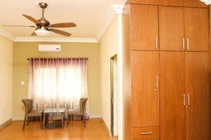 a dining room with a table and a ceiling fan at The Edge in Accra