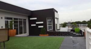 a black and white house with a green yard at The Edge in Accra +2 photos