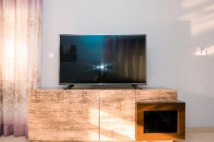 a flat screen tv sitting on top of a wooden entertainment center at The Edge in Accra