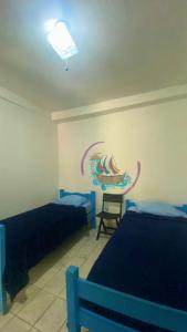 a bedroom with two beds and a painting on the wall at Casinha Blue Pipa in Pipa