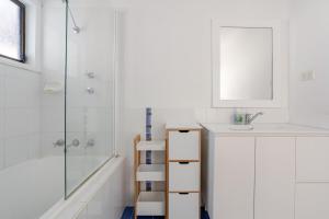 a white bathroom with a sink and a shower at All in One Home Work, Relax & Weekend Escape in Bomaderry +54 photos