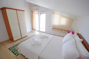 a bedroom with a large white bed and a window at Kaya Apart Datca in Datca