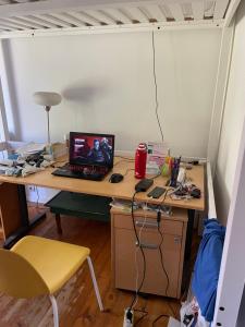 a desk with a laptop computer on top of it at Chambre colocation Lit mezzanine in Nantes
