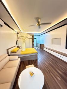 a living room with a couch and a bed at Đầm sen Resort in Hòa Lạc