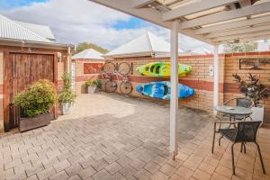 an outdoor patio with a table and an umbrella at Beachside Retreat, WIFI, Kayaks, AC to all rooms in Dunsborough