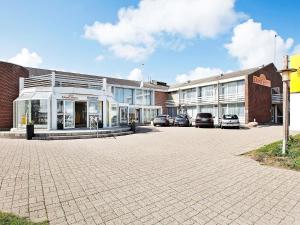 a building with cars parked in a parking lot at 8 person holiday home in Ringkøbing-By Traum in Ringkøbing +35 photos