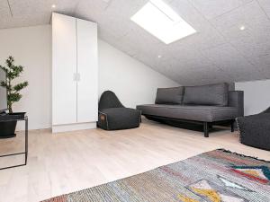 a living room with a couch and a chair at 5 star holiday home in Ringkøbing in Ringkøbing