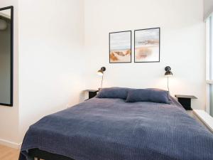 a bedroom with a blue bed with two lamps at 5 star holiday home in Ringkøbing in Ringkøbing +38 photos